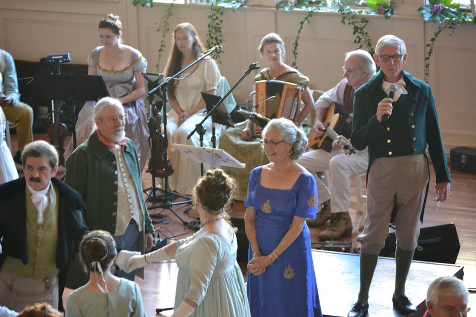 At the Jane Austen Festival Grand Ball back when it was held at Spalding University. Don Corson is calling, Keltricity is playing, and Kathy (in blue) is waiting for her turn to get into the thick of a dance.